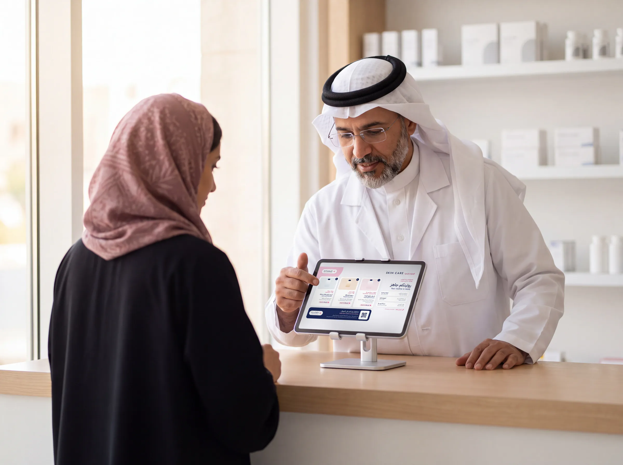A Saudi pharmacist showing a customer a product guide on a counter tablet